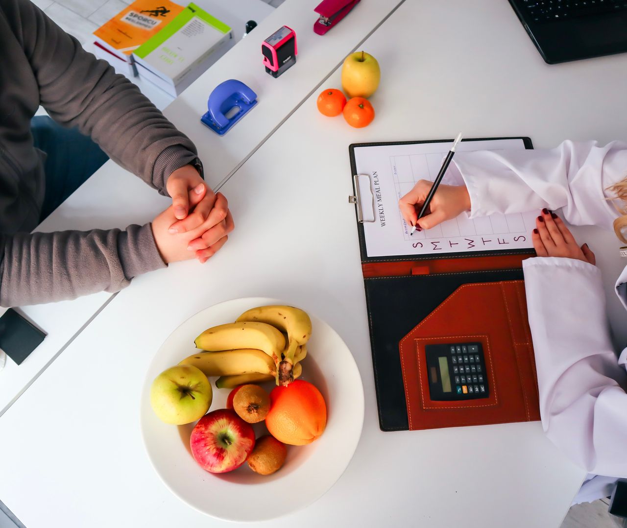 The Art of Drawing Readers In: Your attractive post title goes here Top view of a dietitian planning a healthy diet with fresh fruits on the table, focusing on health and nutrition.